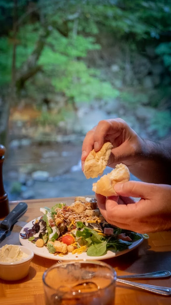 eating bread and salad at river view table